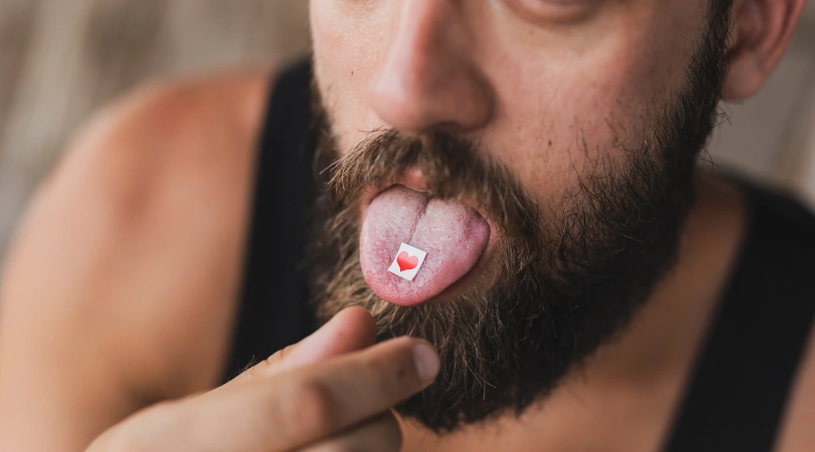 Image of a man sticking out his tongue with an acid strip on it - Can You OD on Acid - South Shores Recovery