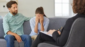 Image of a husband and wife sitting in therapy with a counselor who is looking on - What Are The Stages of EFT Therapy - South Shores Recovery